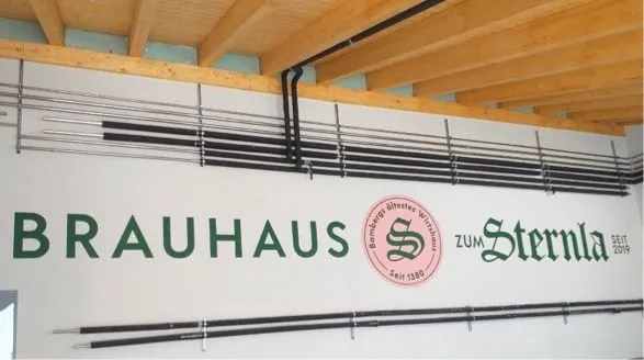 Wand mit dem Schriftzug 'Brauhaus zum Sternla' und dekorativen Elementen in einem hellen Raum.